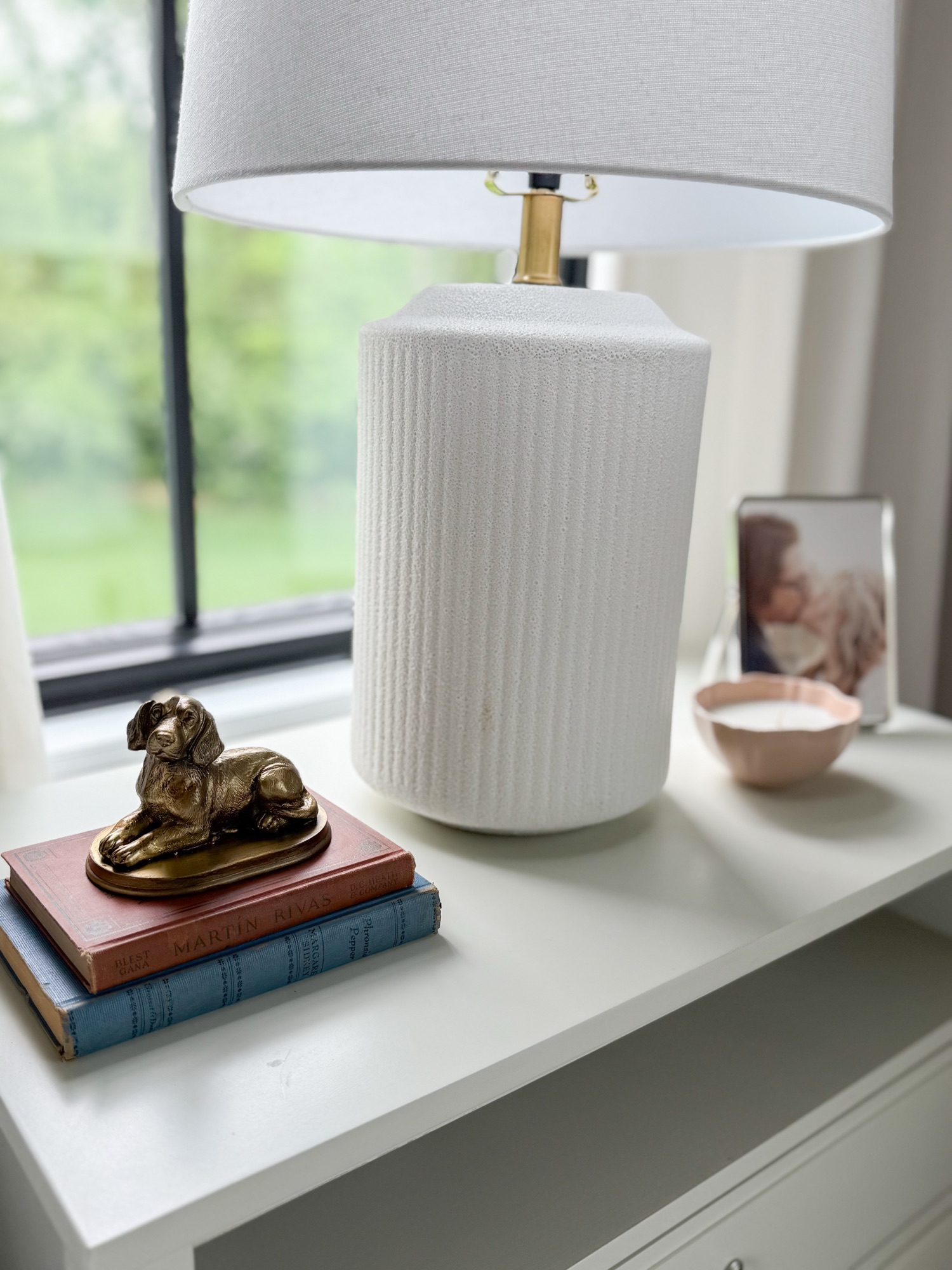 Night stand styled with vintage brass dog and classic silver picture frame