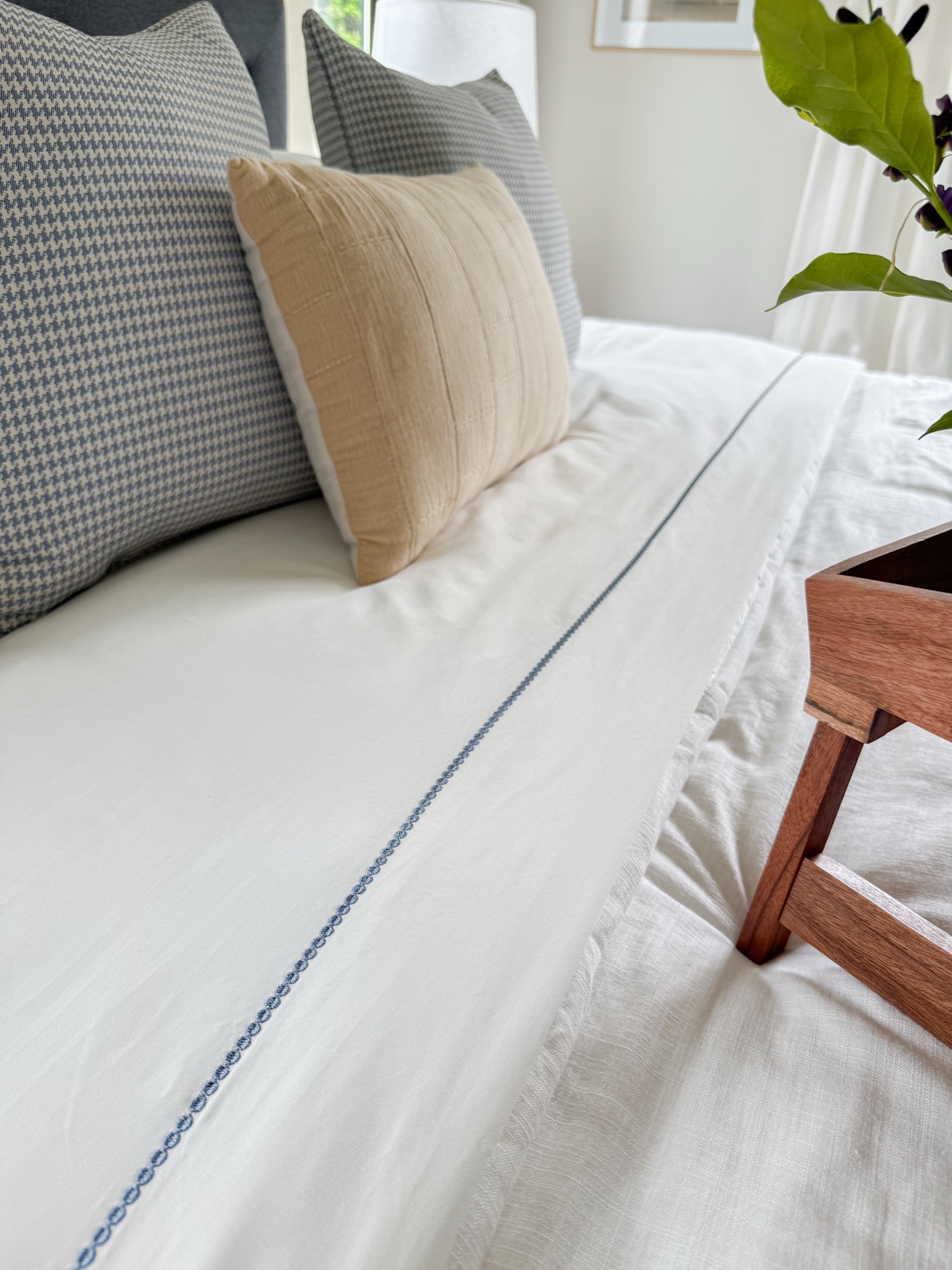 crisp white and blue embroidered sheet set with hounds tooth pillows