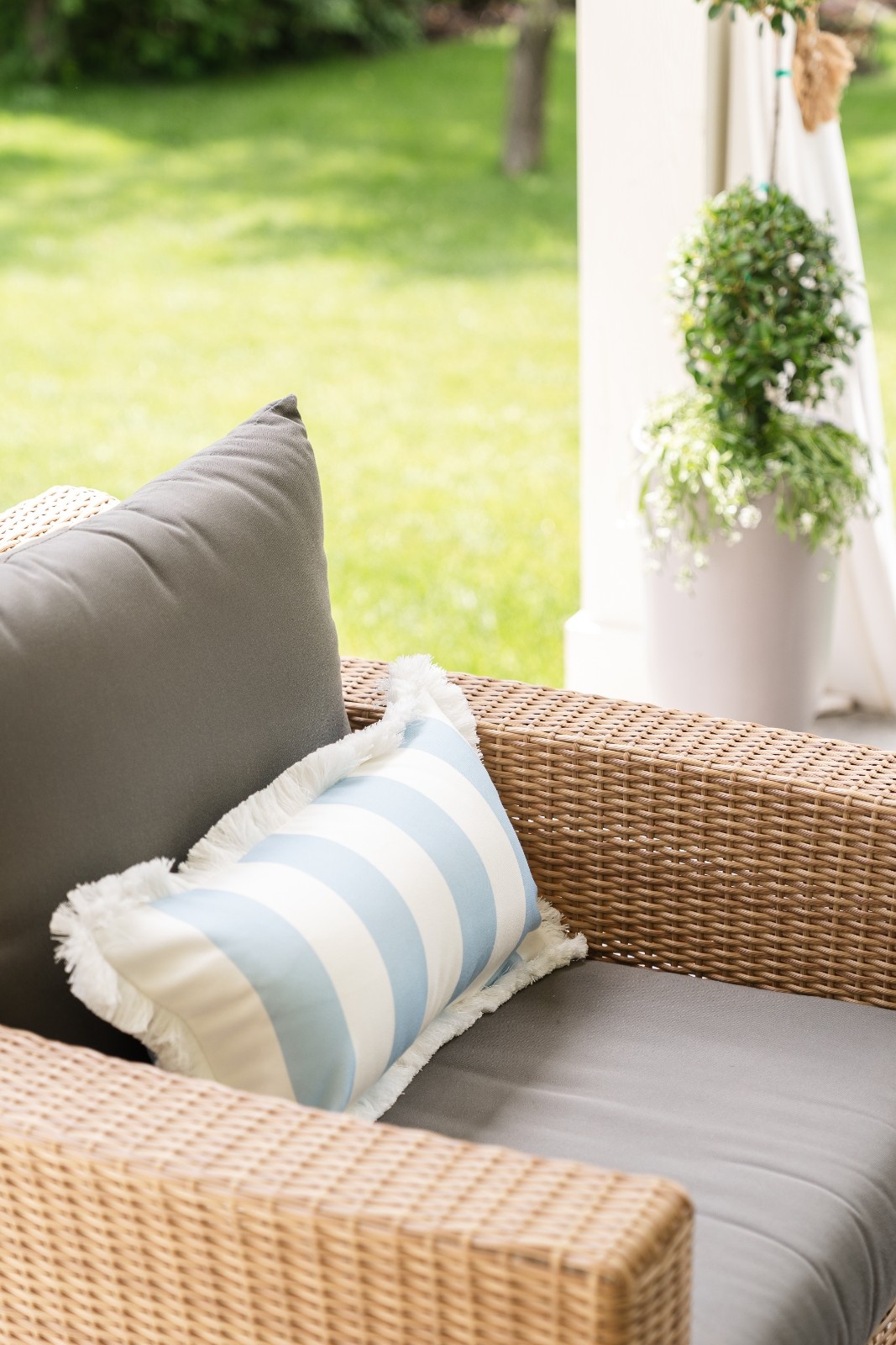 wooven outdoor chair and striped pillow